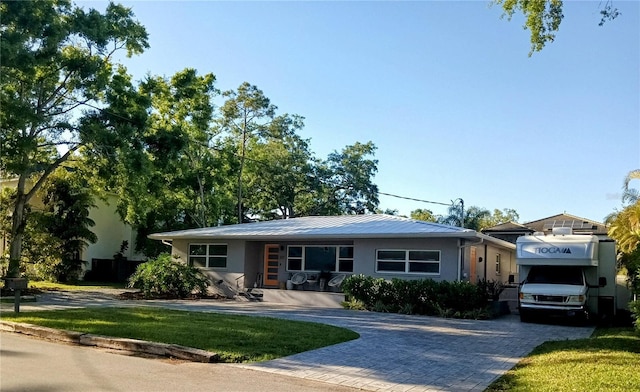 ranch-style home with driveway, a front lawn, and stucco siding