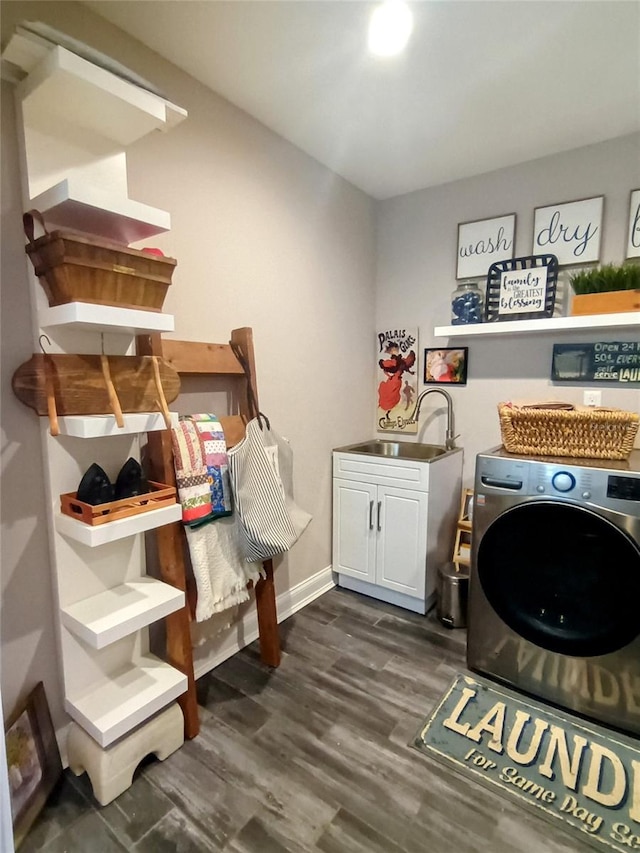 clothes washing area featuring a sink, washer / clothes dryer, baseboards, cabinet space, and dark wood-type flooring