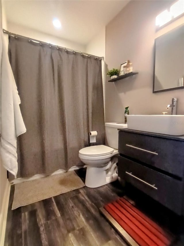 full bathroom featuring a shower with curtain, toilet, wood finished floors, and vanity