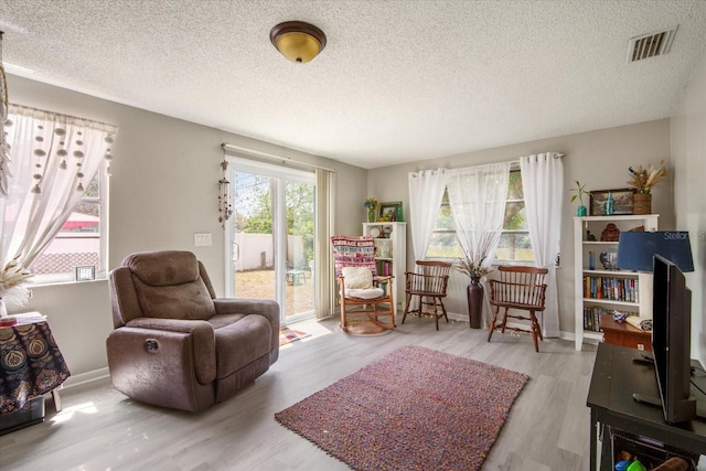5050 68th Way N, Saint Petersburg, FL 33709 - living area featuring a textured ceiling, visible vents, and wood finished floors