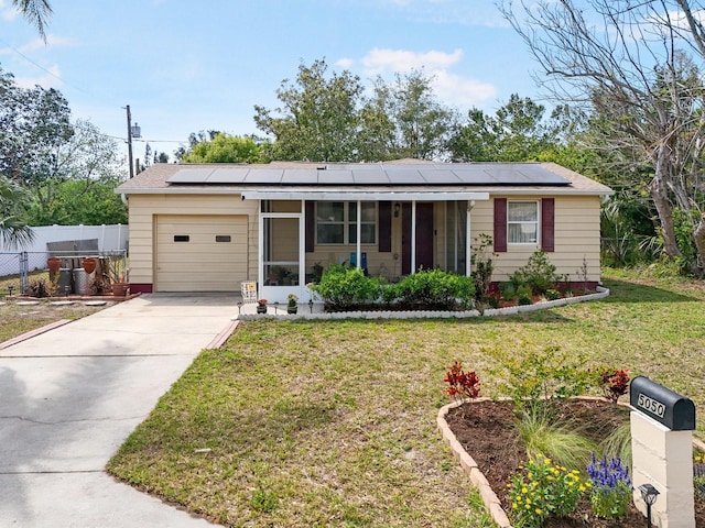 5050 68th Way N, Saint Petersburg, FL 33709 - single story home with a front lawn, solar panels, an attached garage, and concrete driveway