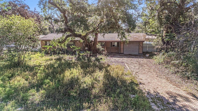 rear view of house with decorative driveway and a garage
