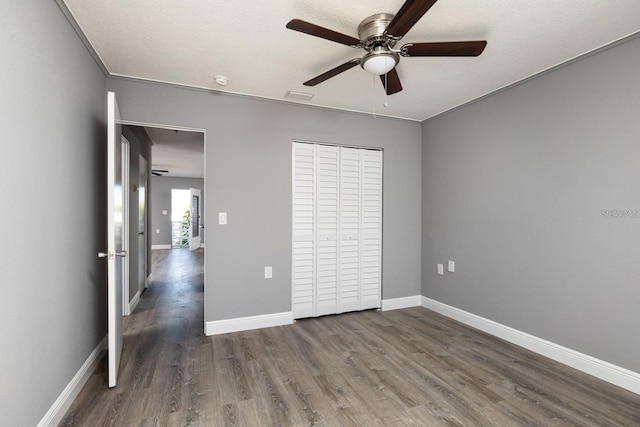 8555 112th St Unit 209, Seminole, FL 33772 - unfurnished bedroom with a closet, baseboards, visible vents, ceiling fan, and dark wood-style flooring