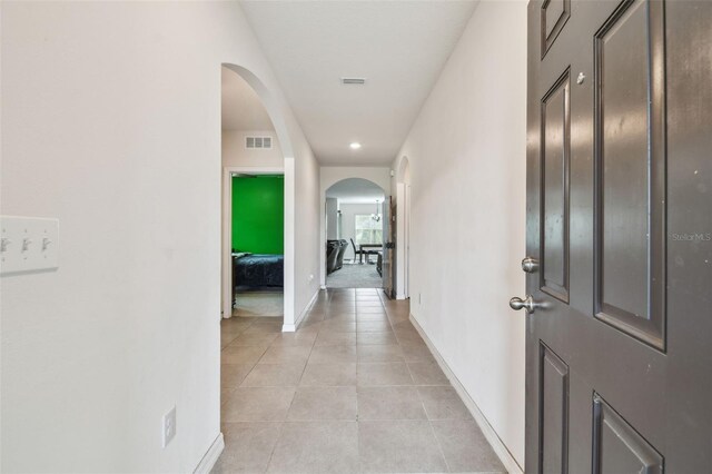 6882 Silverado Ranch Blvd, Zephyrhills, FL 33541 - hall with baseboards, visible vents, arched walkways, and light tile patterned flooring