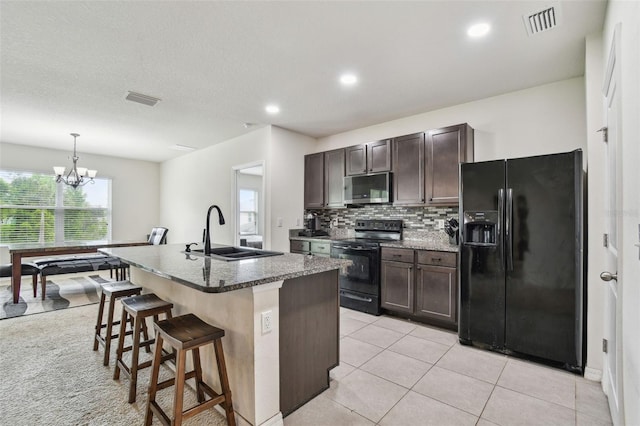 6882 Silverado Ranch Blvd, Zephyrhills, FL 33541 - kitchen featuring black appliances, dark brown cabinetry, a sink, and visible vents
