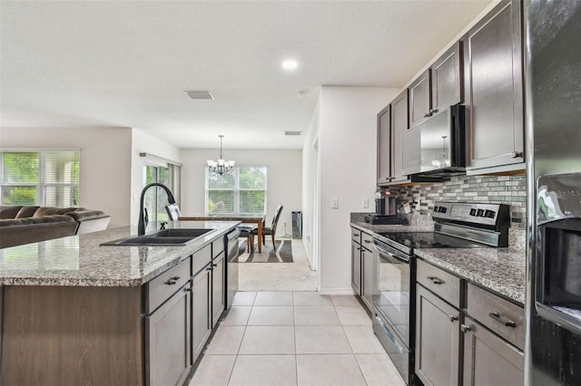 6882 Silverado Ranch Blvd, Zephyrhills, FL 33541 - kitchen with a sink, decorative backsplash, an inviting chandelier, a center island with sink, and appliances with stainless steel finishes
