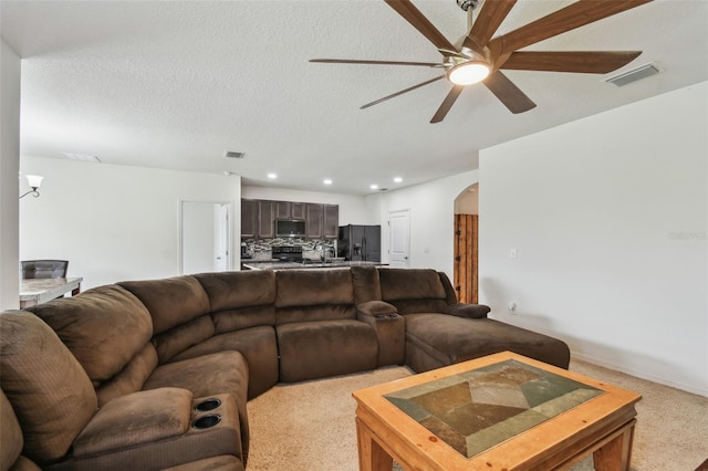 6882 Silverado Ranch Blvd, Zephyrhills, FL 33541 - living room featuring arched walkways, visible vents, a ceiling fan, and light colored carpet