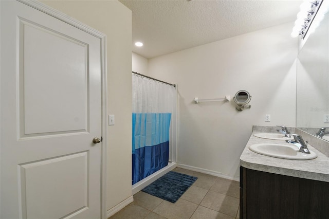 6882 Silverado Ranch Blvd, Zephyrhills, FL 33541 - bathroom featuring baseboards, tile patterned flooring, a sink, and a textured ceiling