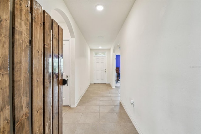 6882 Silverado Ranch Blvd, Zephyrhills, FL 33541 - hall featuring light tile patterned flooring, arched walkways, and baseboards