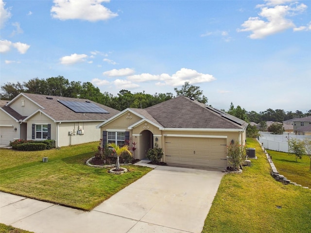 6882 Silverado Ranch Blvd, Zephyrhills, FL 33541 - ranch-style home with solar panels, an attached garage, a front lawn, and stucco siding