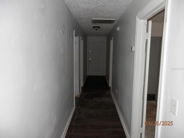 851 Easy St, Brooksville, FL 34601 - corridor featuring baseboards, visible vents, dark wood-type flooring, and a textured ceiling