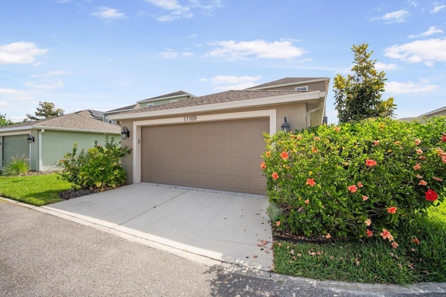 view of front of house featuring concrete driveway, an attached garage, a shingled roof, and stucco siding