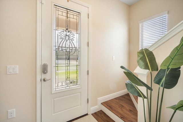 doorway to outside with a healthy amount of sunlight, baseboards, and wood finished floors