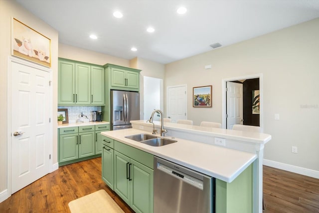 kitchen featuring stainless steel appliances, green cabinetry, dark wood-style floors, and a sink