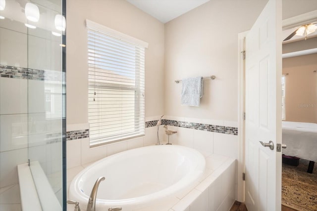 bathroom with a garden tub, ensuite bath, and tiled shower