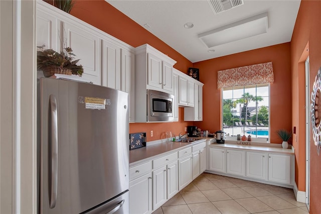 kitchen with visible vents, light countertops, white cabinetry, and stainless steel appliances