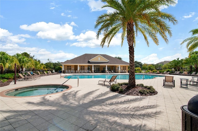 pool featuring a hot tub, a patio, and fence