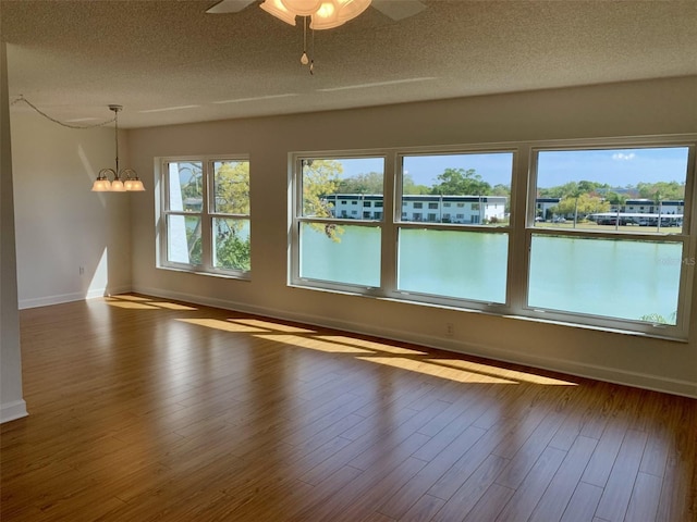 1655 S Highland Ave Unit I286, Clearwater, FL 33756 - empty room featuring baseboards, a chandelier, ceiling fan, a textured ceiling, and wood finished floors