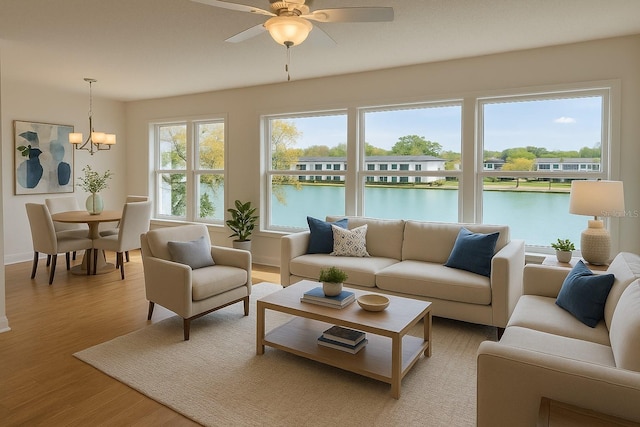 1655 S Highland Ave Unit I286, Clearwater, FL 33756 - living area featuring light wood-style flooring, a ceiling fan, a water view, a chandelier, and baseboards
