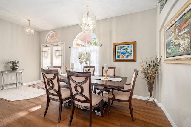 dining area with baseboards, wood finished floors, and a chandelier
