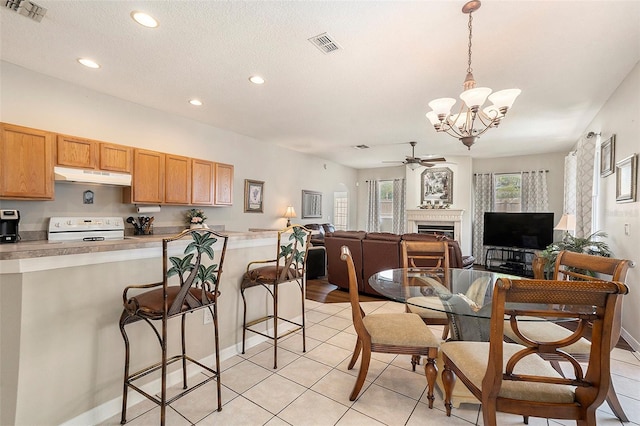 kitchen with under cabinet range hood, white stove, visible vents, and recessed lighting