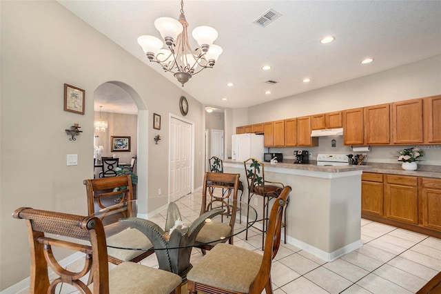 kitchen with an inviting chandelier, white appliances, arched walkways, recessed lighting, and under cabinet range hood
