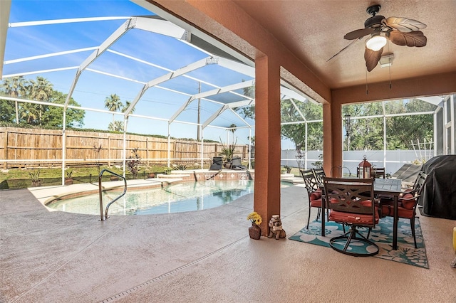 view of swimming pool featuring a patio, a fenced backyard, a fenced in pool, a ceiling fan, and glass enclosure