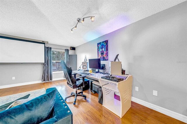 13122 Prestwick Dr, Riverview, FL 33579 - home office featuring track lighting, baseboards, wood finished floors, and a textured ceiling