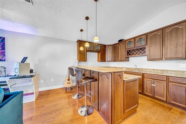 13122 Prestwick Dr, Riverview, FL 33579 - kitchen featuring light wood-style floors, glass insert cabinets, vaulted ceiling, and a kitchen breakfast bar