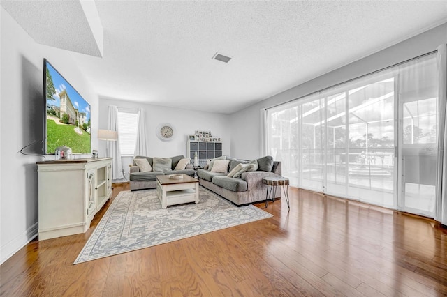 13122 Prestwick Dr, Riverview, FL 33579 - living room with visible vents, a textured ceiling, and wood finished floors