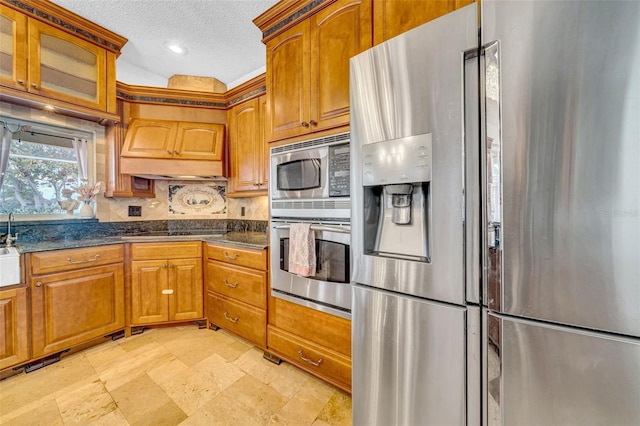 13122 Prestwick Dr, Riverview, FL 33579 - kitchen with brown cabinetry, a textured ceiling, stainless steel appliances, premium range hood, and backsplash
