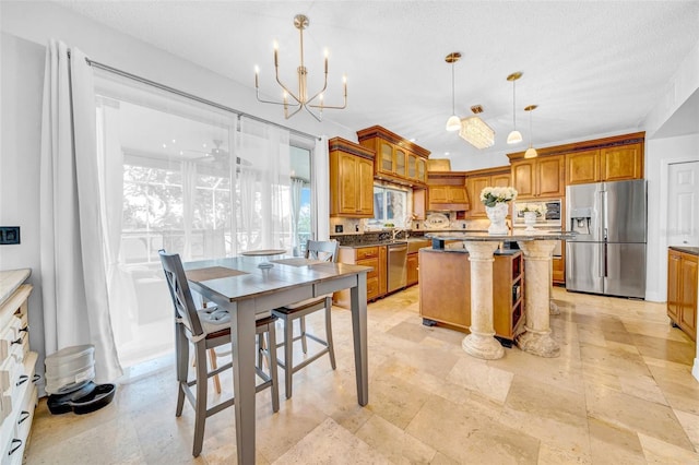 13122 Prestwick Dr, Riverview, FL 33579 - kitchen with decorative light fixtures, a notable chandelier, appliances with stainless steel finishes, brown cabinetry, and a kitchen island