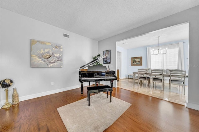 13122 Prestwick Dr, Riverview, FL 33579 - living area with visible vents, baseboards, a chandelier, a textured ceiling, and wood finished floors