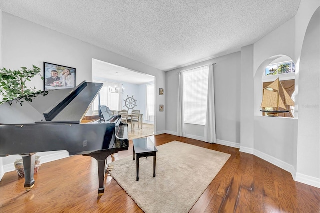 13122 Prestwick Dr, Riverview, FL 33579 - living area featuring a chandelier, baseboards, a textured ceiling, and wood finished floors