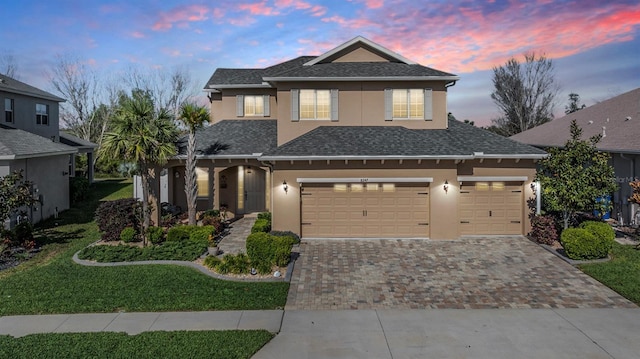 8247 Westhaven Dr, Land O Lakes, FL 34638 - traditional-style house with decorative driveway, stucco siding, a garage, a lawn, and a shingled roof