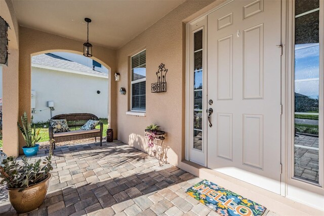 8247 Westhaven Dr, Land O Lakes, FL 34638 - doorway to property with stucco siding and a porch