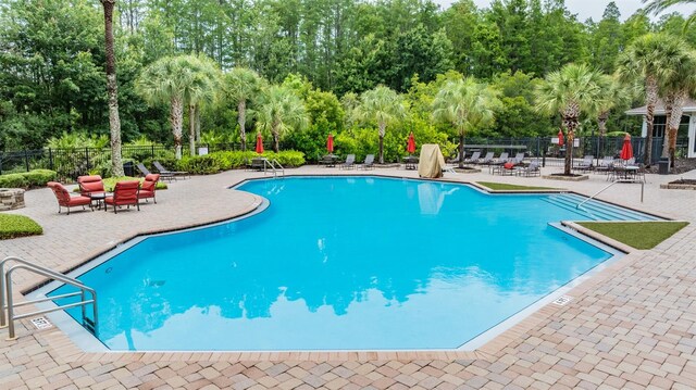 8247 Westhaven Dr, Land O Lakes, FL 34638 - community pool with view of scattered trees and a patio area
