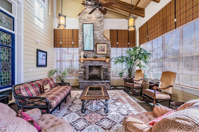 8247 Westhaven Dr, Land O Lakes, FL 34638 - living room featuring high vaulted ceiling, ceiling fan, a stone fireplace, plenty of natural light, and beamed ceiling