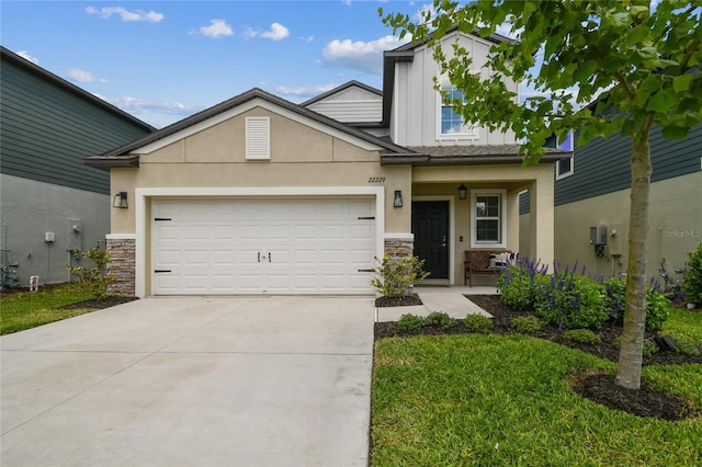 view of front of property with a garage, driveway, stone siding, and stucco siding