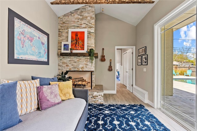 living room with wood finished floors, high vaulted ceiling, a fireplace, and baseboards