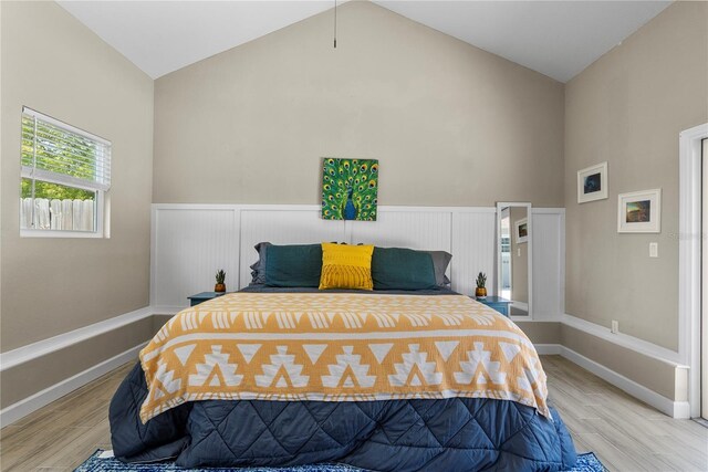 bedroom with baseboards, light wood finished floors, and lofted ceiling