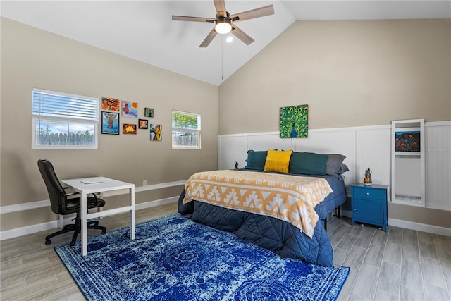 bedroom featuring baseboards, light wood finished floors, vaulted ceiling, and a ceiling fan
