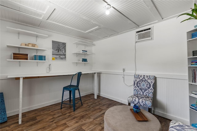 interior space featuring dark wood-type flooring, an AC wall unit, and wainscoting