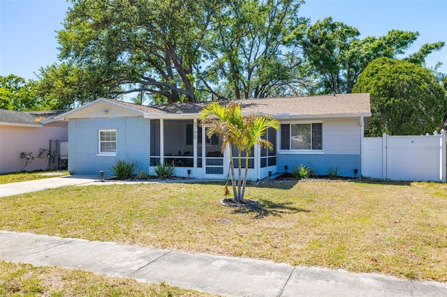 8766 91st St, Seminole, FL 33777 - ranch-style home featuring brick siding, a sunroom, a front lawn, and fence