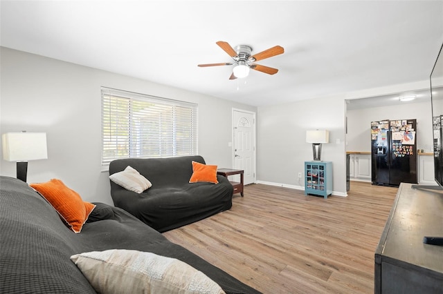 8766 91st St, Seminole, FL 33777 - living area featuring light wood-style flooring, a ceiling fan, and baseboards