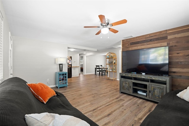 8766 91st St, Seminole, FL 33777 - living area with a ceiling fan, wood walls, wood finished floors, baseboards, and visible vents