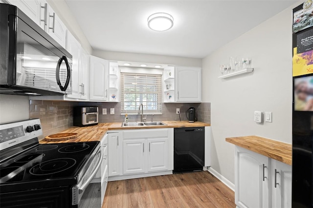 8766 91st St, Seminole, FL 33777 - kitchen featuring light wood-style flooring, a sink, butcher block countertops, open shelves, and black appliances