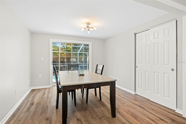 8766 91st St, Seminole, FL 33777 - dining space featuring wood finished floors, baseboards, and an inviting chandelier