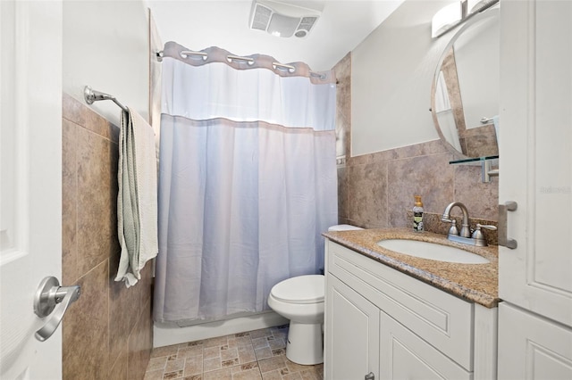 8766 91st St, Seminole, FL 33777 - full bathroom with vanity, tile walls, a wainscoted wall, toilet, and visible vents