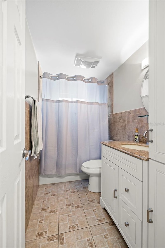 8766 91st St, Seminole, FL 33777 - full bath featuring tile walls, visible vents, toilet, and vanity